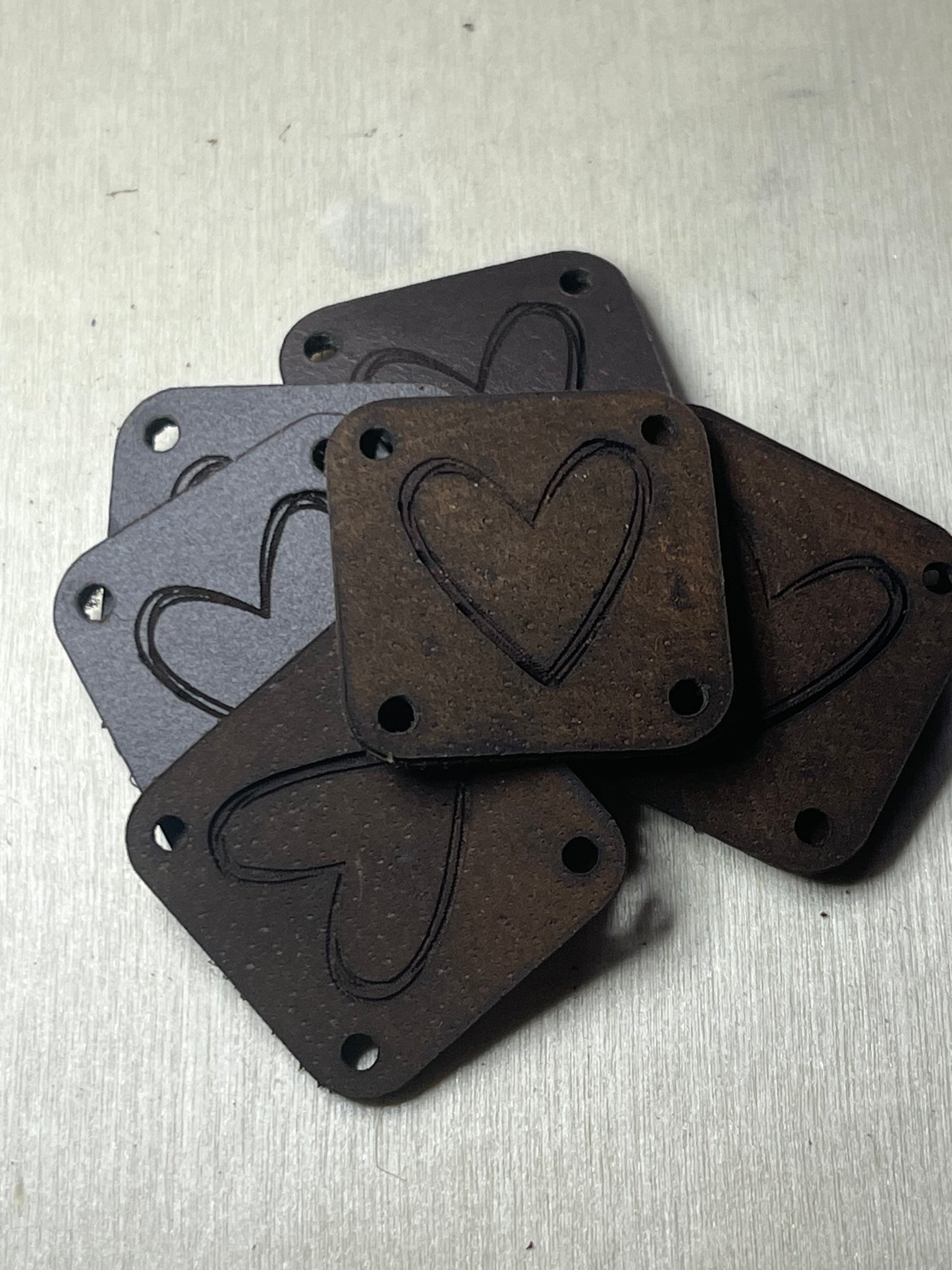 1"x1" rounded square with 4 side holes - etched heart